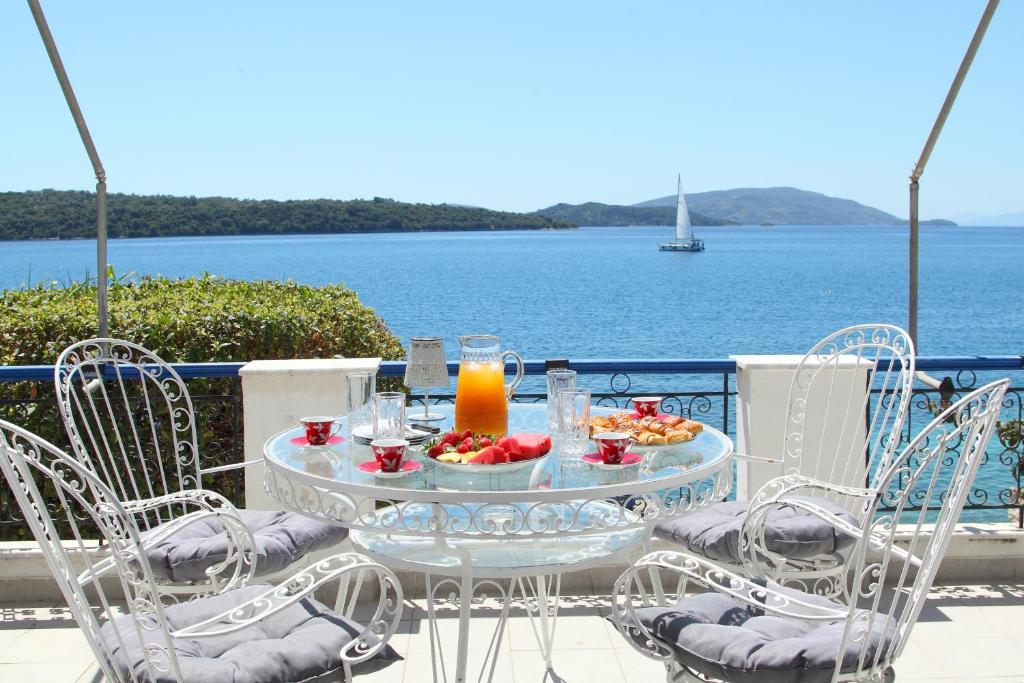 a table with a bowl of fruit and a candle on it at Villa Violeta Lefkada Nydri in Nydri