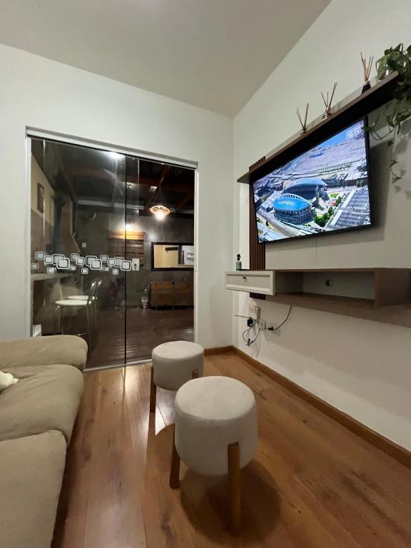 a living room with a couch and a flat screen tv at Apartamento Confortável com Área Gourmet in Fazenda Rio Grande