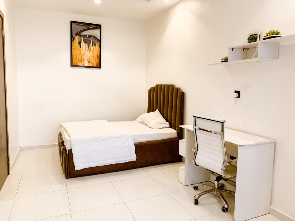 a bedroom with a bed and a desk and a computer at Ezko Apartments Lagos Business School in Lekki