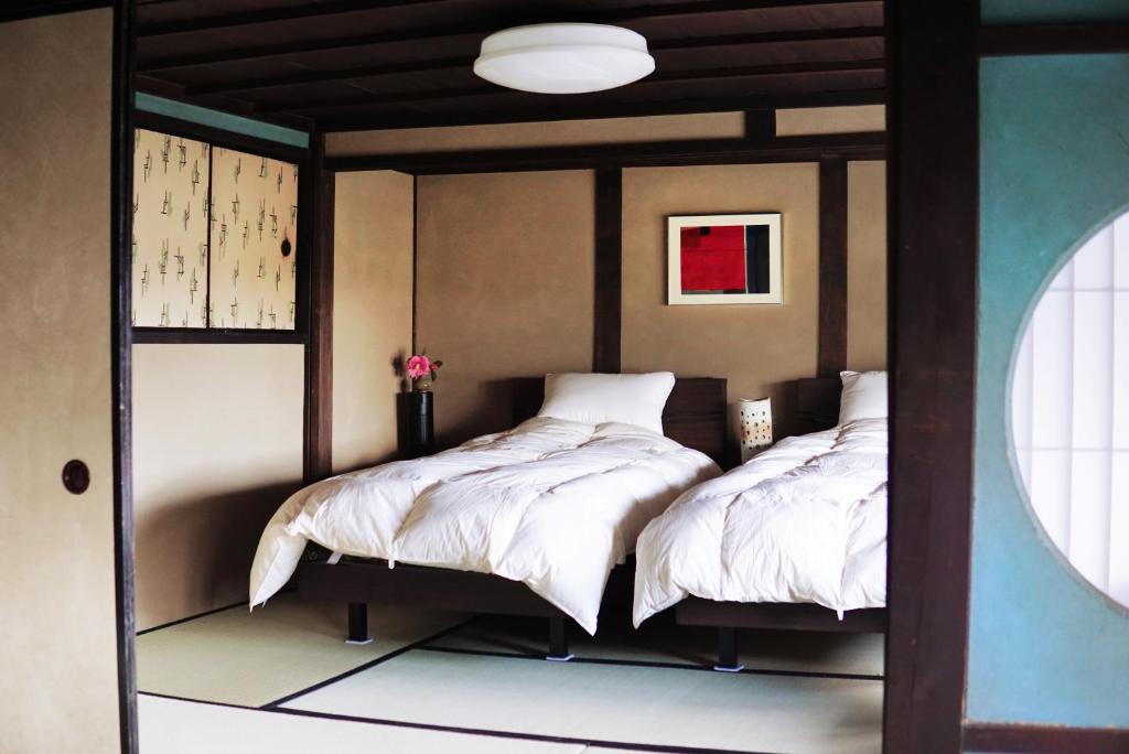 Postel nebo postele na pokoji v ubytování 多賀さとの宿 一圓屋敷