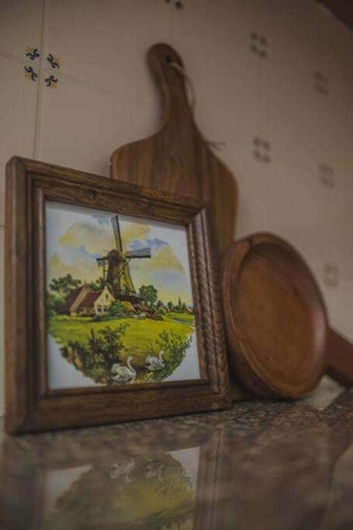 a painting of a windmill and a wooden bowl at Casa Borda da Rocha in Nordeste