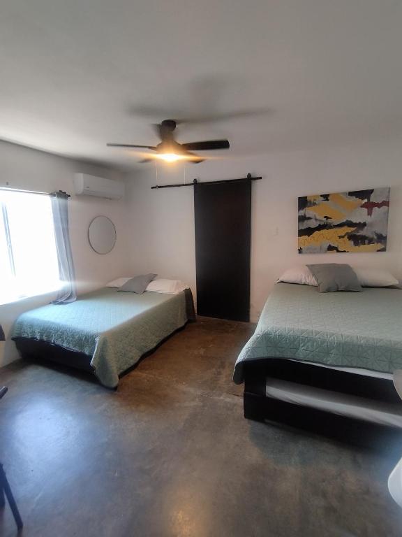 a bedroom with two beds and a ceiling fan at DGM Lofts MTY MN 960 G centro cerca de todo in Monterrey