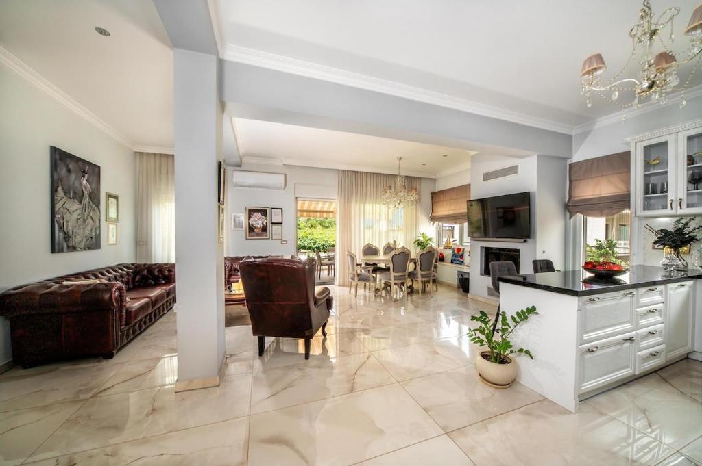 Una gran sala de estar con un sofá y una mesa. en Evis coastal comfort house, en Kalamaki