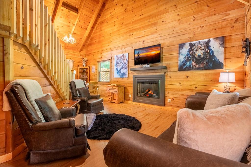 een woonkamer met een open haard in een blokhut bij Quiet Way Cabin By Avada Properties in Sevierville