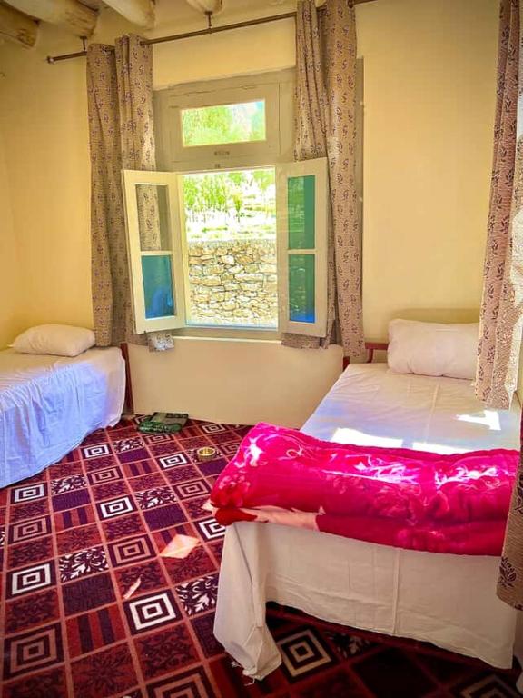 a bedroom with two beds and a window at K6 Hotel & Camping Kande in Kande