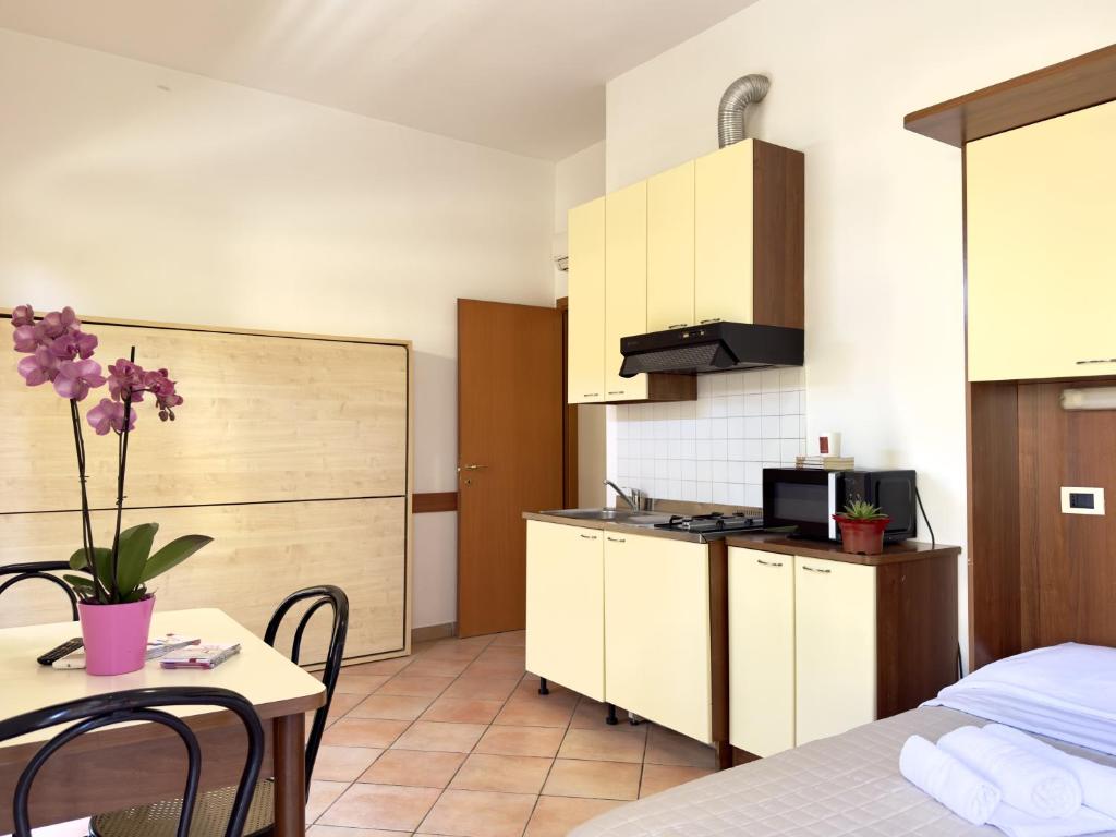 a small kitchen with a table and a kitchen gmaxwell gmaxwell gmaxwell gmaxwell gmaxwell at Residence Carioca in Rimini