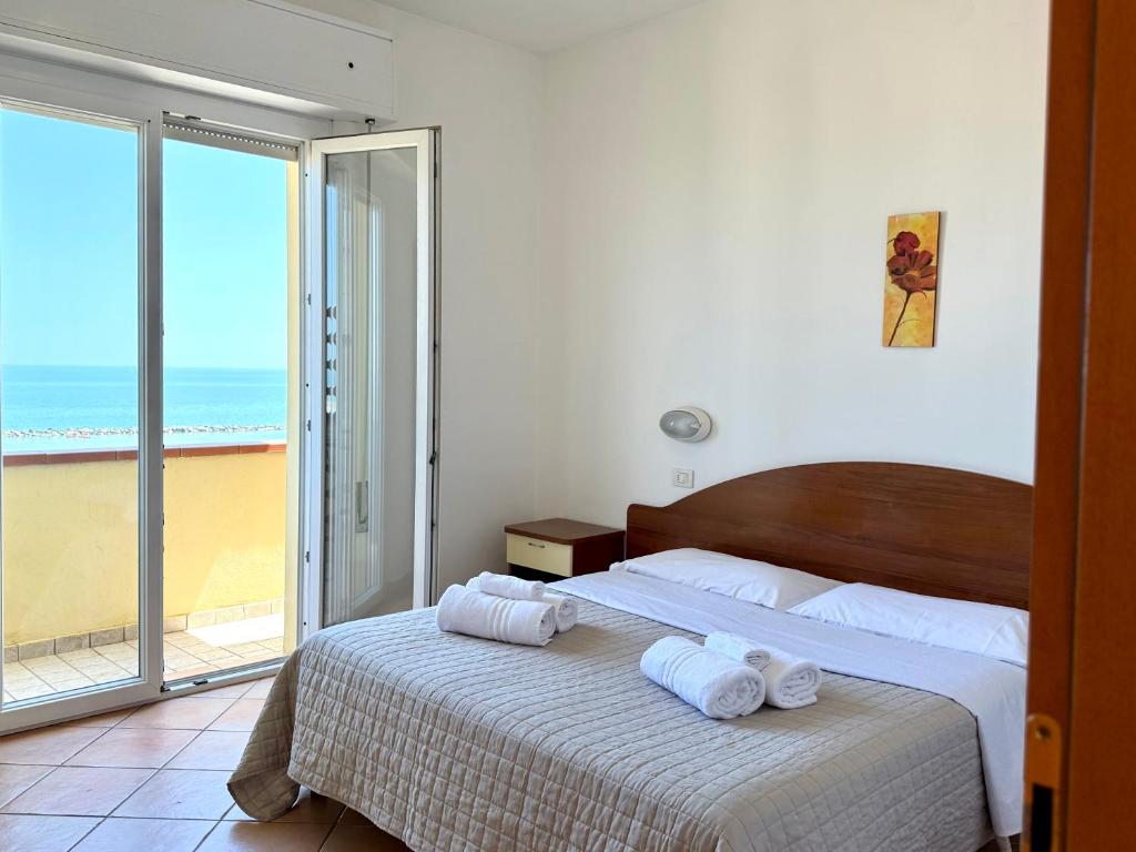 a bedroom with a bed with two towels on it at Residence Carioca in Rimini