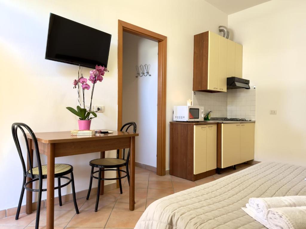 a hotel room with a table and a bed and a kitchen at Residence Carioca in Rimini