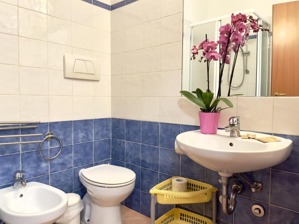 a blue and white bathroom with a toilet and a sink at Residence Carioca in Rimini