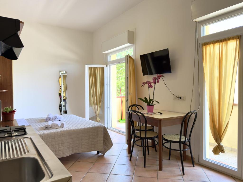 a kitchen and living room with a table and chairs at Residence Carioca in Rimini