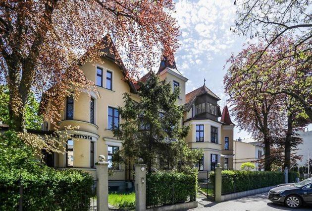 a large white house with a fence in front of it at Premium Basement Apartament by Vibe Hostel in Sopot