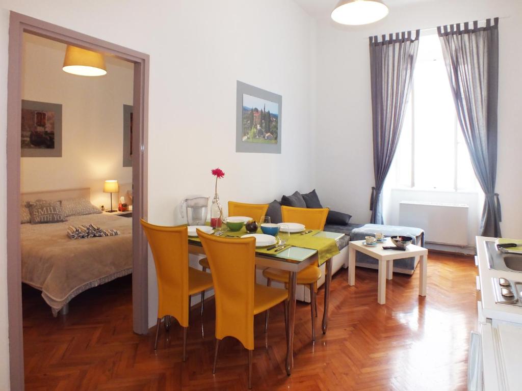 a dining room and living room with a table and chairs at Apartman Draguć in Pula