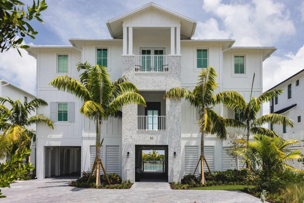 a white building with palm trees in front of it at New Waterfront Home - Dreamside House in Key West