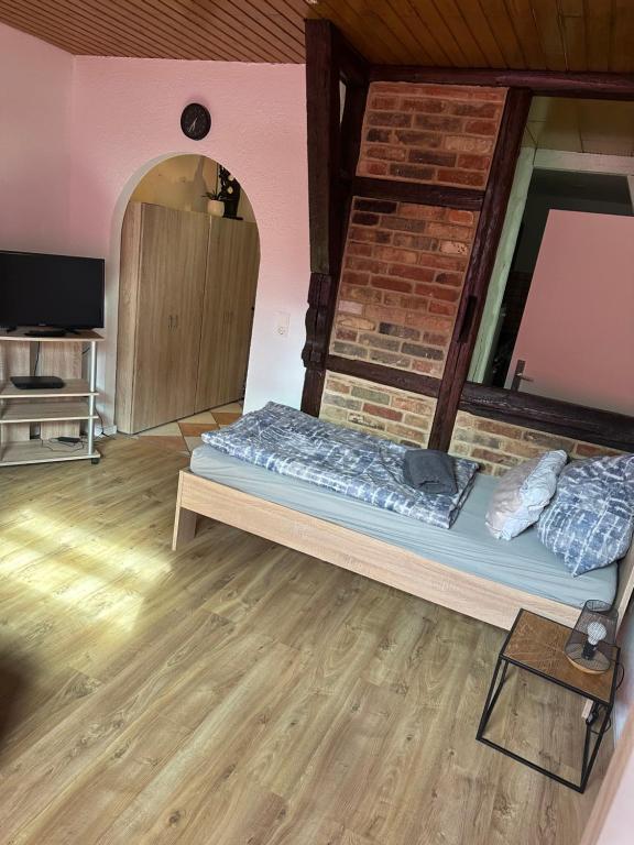 a room with a bed and a brick wall at 1-Zimmer-Wohnung Astfeld in Langelsheim