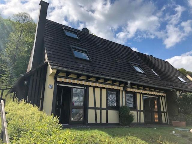 una casa con tetto nero e finestre di Cottage des Cîmes a Climbach