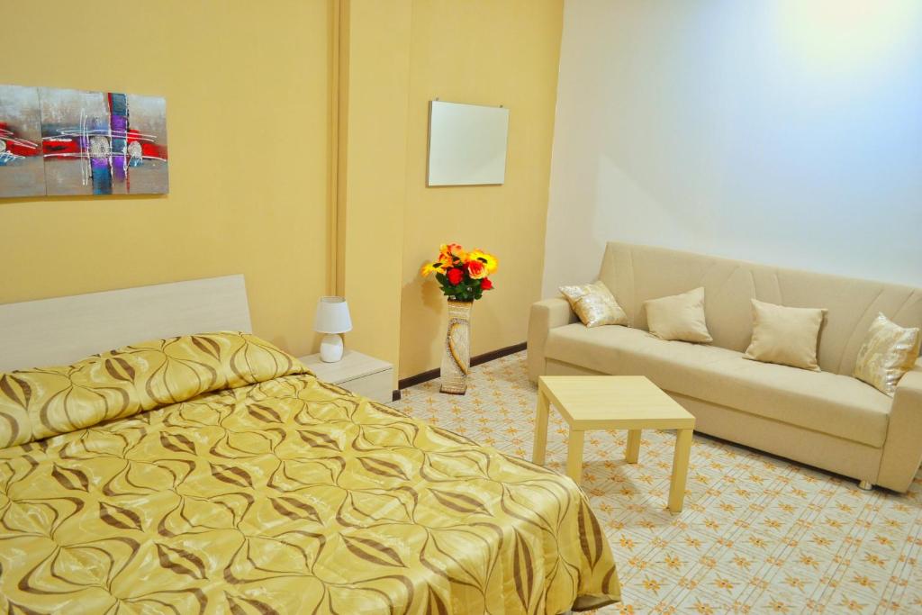 カターニアにあるB&B Lungomareのベッドとソファ付きのホテルルーム