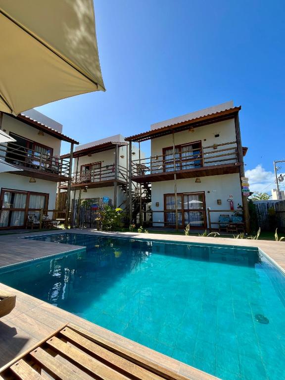 a swimming pool in front of a building at Jangadas do Toque Milagres Flats no Térreo in São Miguel dos Milagres
