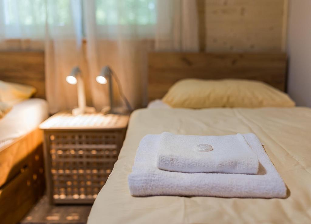 ein Handtuch, das in einem Zimmer auf dem Bett liegt in der Unterkunft Domki Nad Potokiem in Wańkowa