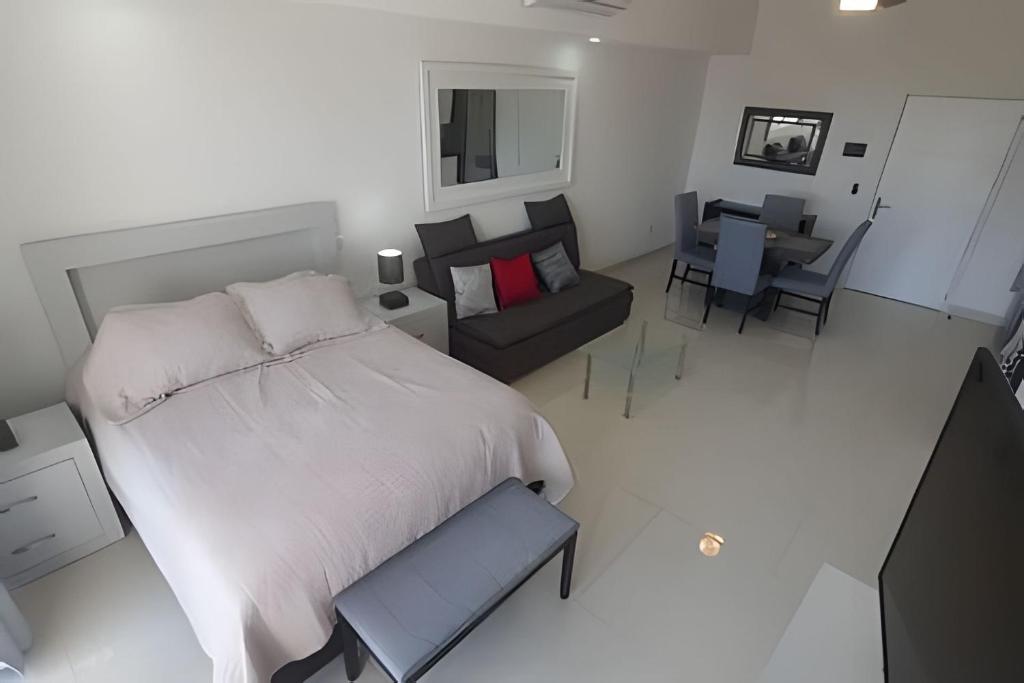 a bedroom with a large bed and a living room at Costa Paraíso D-9 Estudio in Bucerías