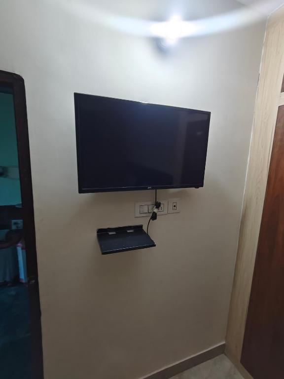 a flat screen tv hanging on a wall at Bad properrty in Vrindāvan