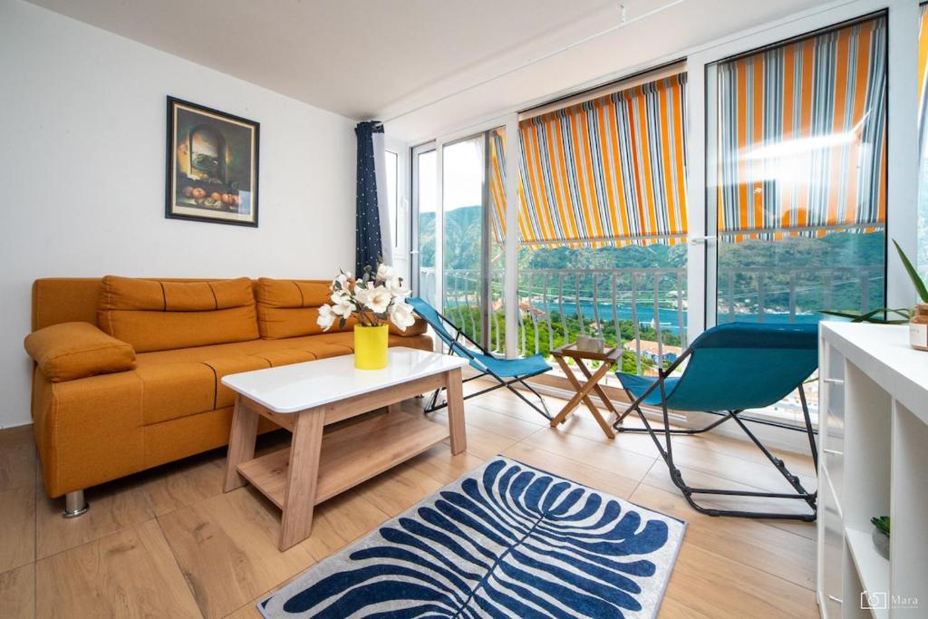 un salon avec un canapé, une table et des chaises dans l'établissement 369 Apartment, à Kotor