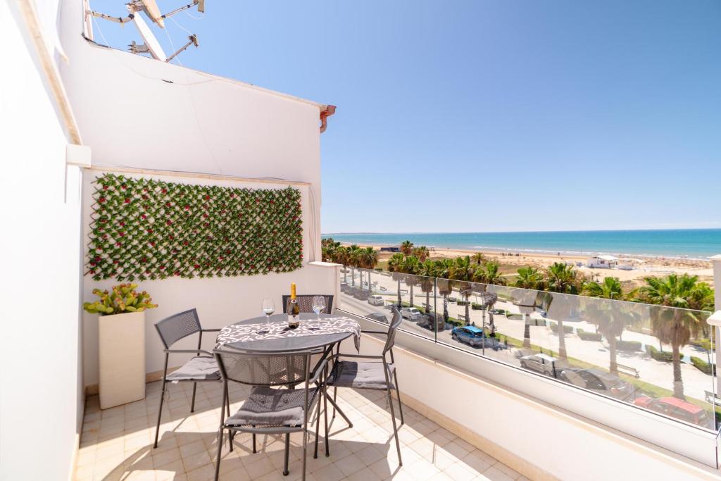 a balcony with a table and chairs and a view of the beach at MADAGÌ Beachfront Apartments in Pozzallo