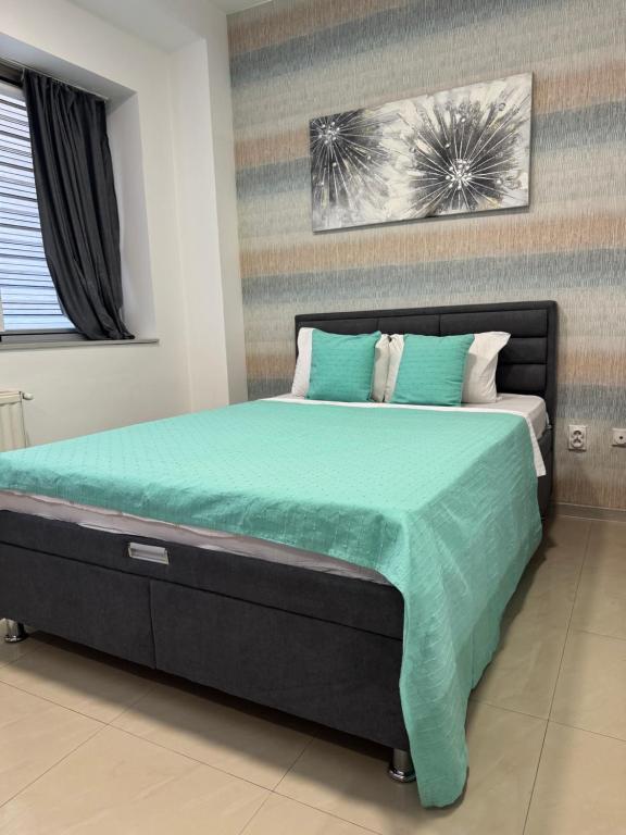 a bedroom with a large bed with green sheets and pillows at SpaNish apartman 6 in Niš