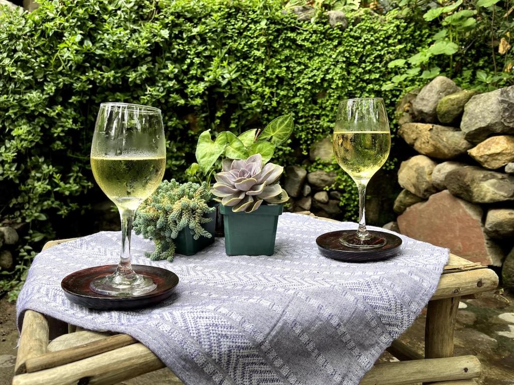 two glasses of wine sitting on a table at Atitlán Stone in Casa Papagayo in San Marcos La Laguna