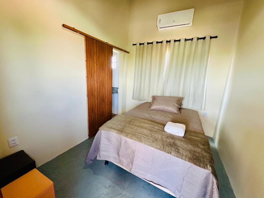 una piccola camera da letto con un letto e una finestra di Casa do Bento - Lençóis Maranheses a Santo Amaro