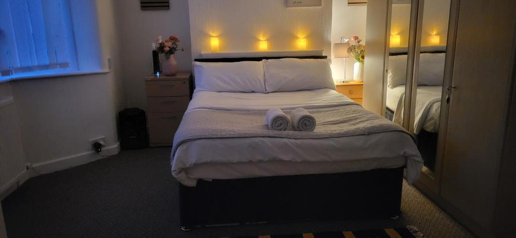 a bedroom with a large bed with two shoes on it at Lovely room like a home away home near the airport in Wythenshawe