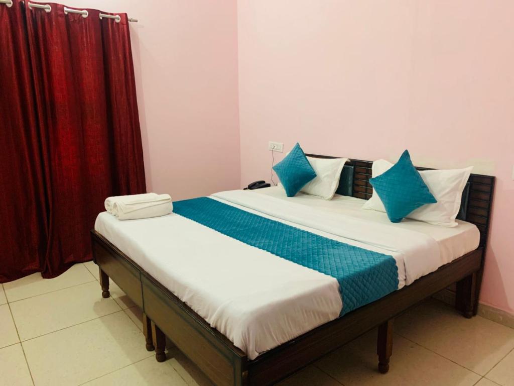 Chandigarh AirportMahadev Homestay !! Preferred Partner ! Walking Distance To Chandigarh Int'l Airport !的卧室里有一张床，上面有蓝白色的枕头