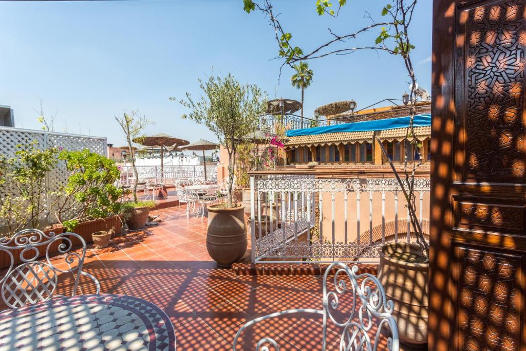 eine Terrasse mit Tischen und Stühlen und ein Gebäude in der Unterkunft Hotel Atlas in Marrakesch