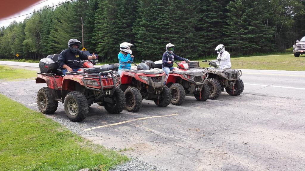 a group of people riding atvs on a road at Deer Mountain Lodge & Wilderness Resort in Dummer