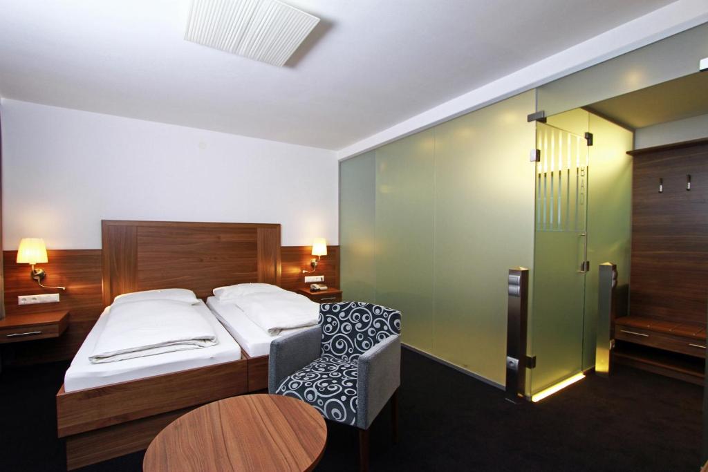 1 dormitorio con 1 cama, 1 silla y 1 mesa en Pension am Kurpark, en Viena