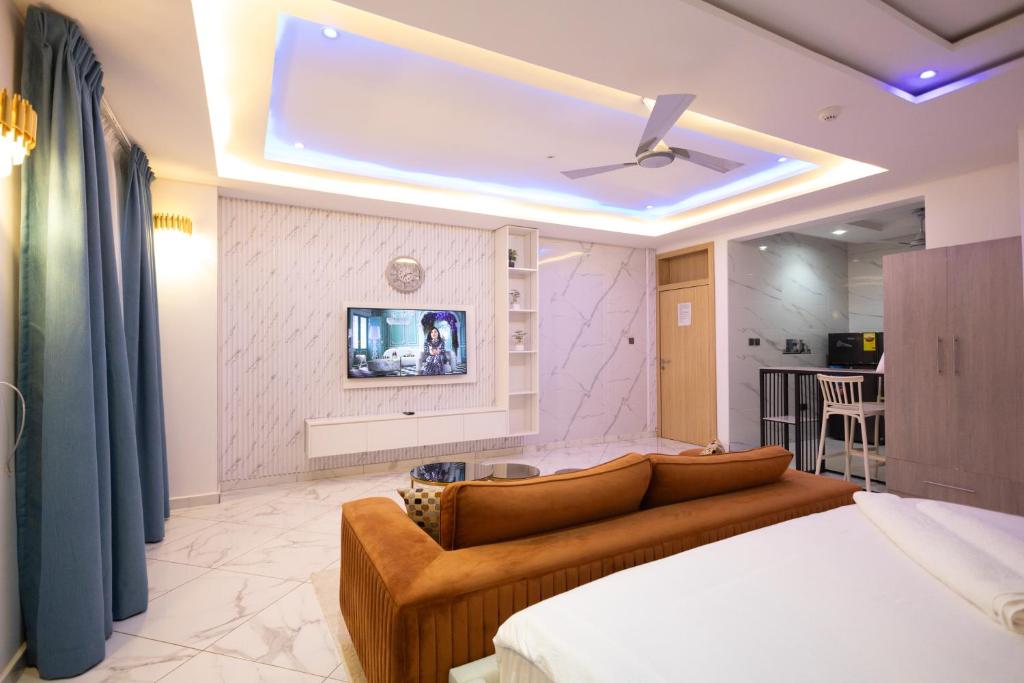 a living room with a couch and a tv at Executive Studio Apartment, East Airport in Accra