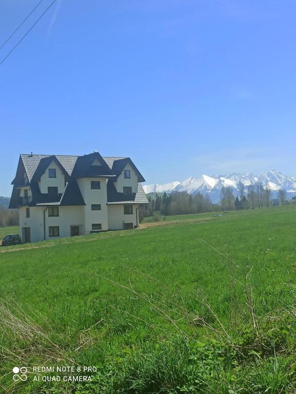 a house in a field with mountains in the background at Stramówka in Groń