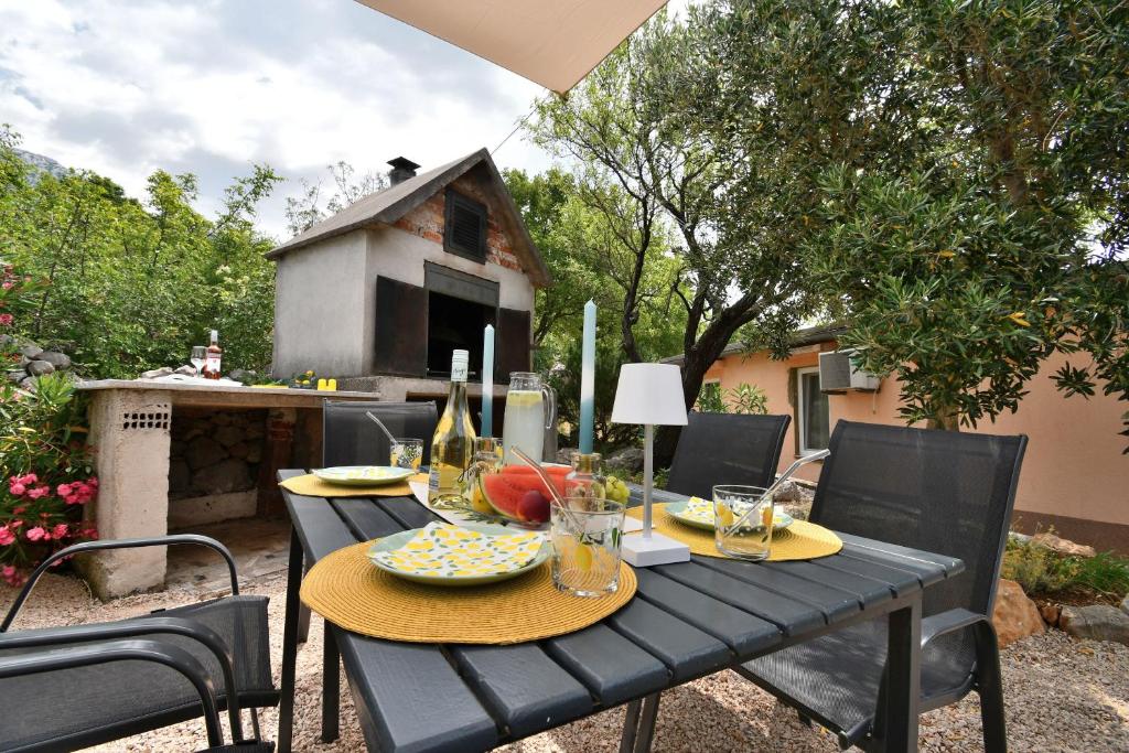 a black table with plates of food on a patio at House Velebit by the sea in Stinica