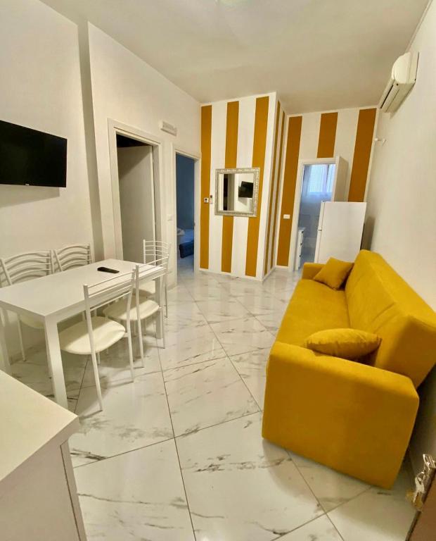 a living room with a yellow couch and a table at Casa Bellemo in Chioggia