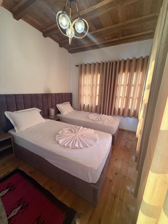 a bedroom with two beds and a chandelier at Hotel Borklad in Berat