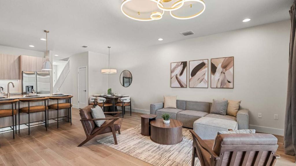 a living room with a couch and a kitchen at Upstay Pristine 3BR Home with Private Pool & BBQ in Orlando