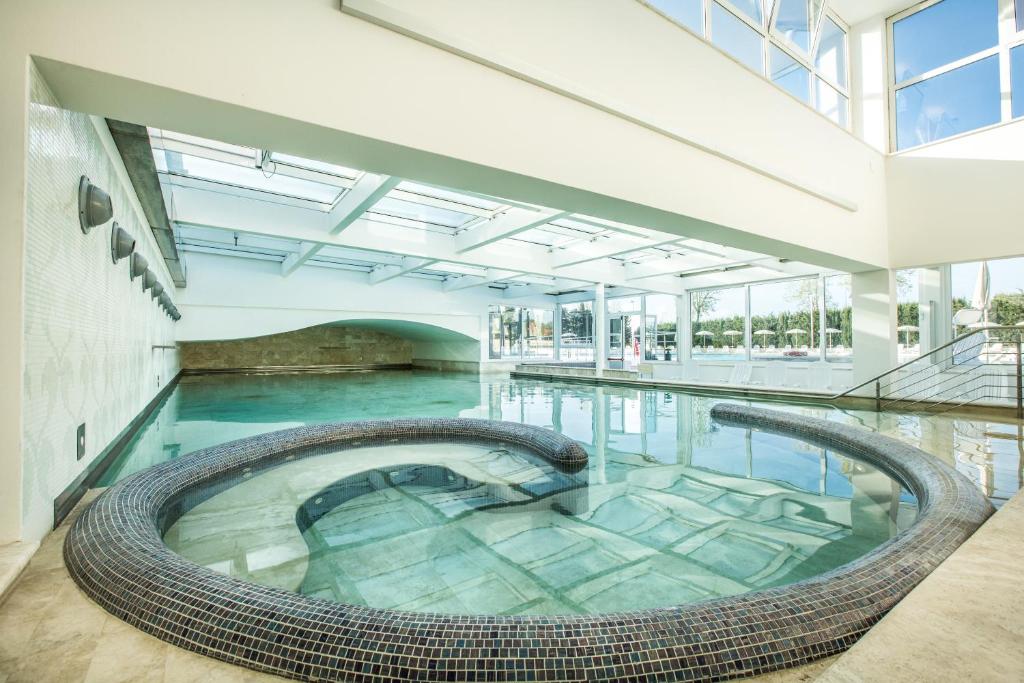 une piscine intérieure avec une grande piscine d'eau dans l'établissement Hotel Delle Terme Di Venturina, à Venturina Terme