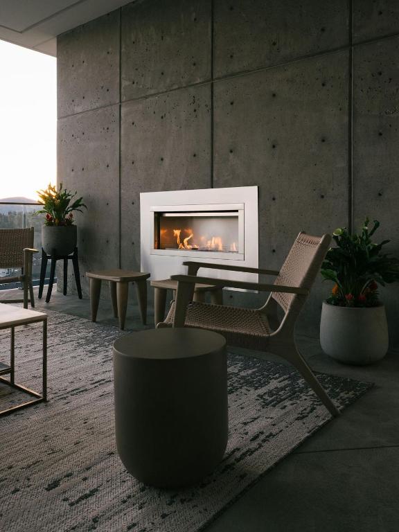 a living room with a fireplace and a chair at Bialto Bed and Breakfast in Penticton