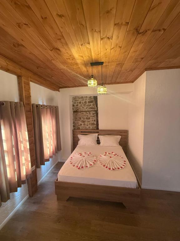 a bedroom with a bed with a wooden ceiling at Hotel Borklad in Berat