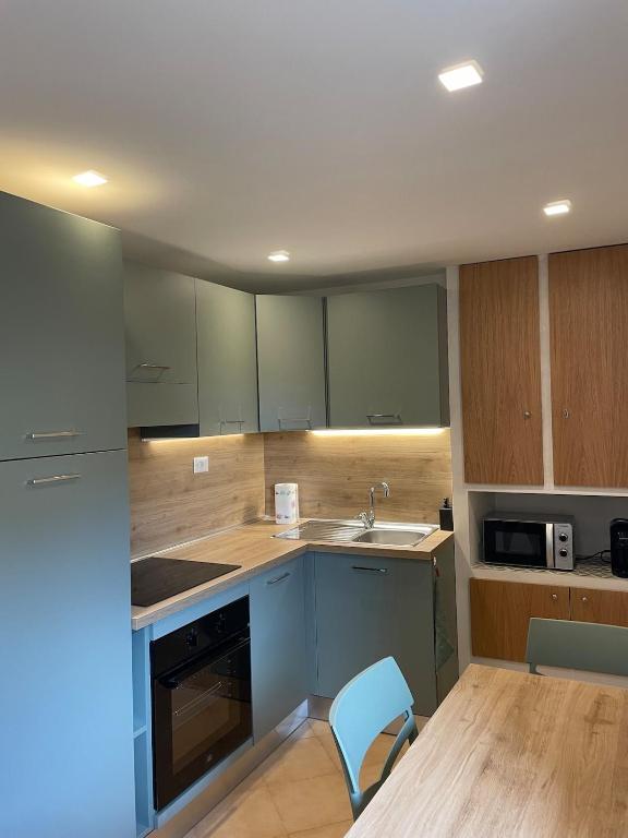 a kitchen with green cabinets and a sink and a chair at Il Nido di Poppi in Poppi