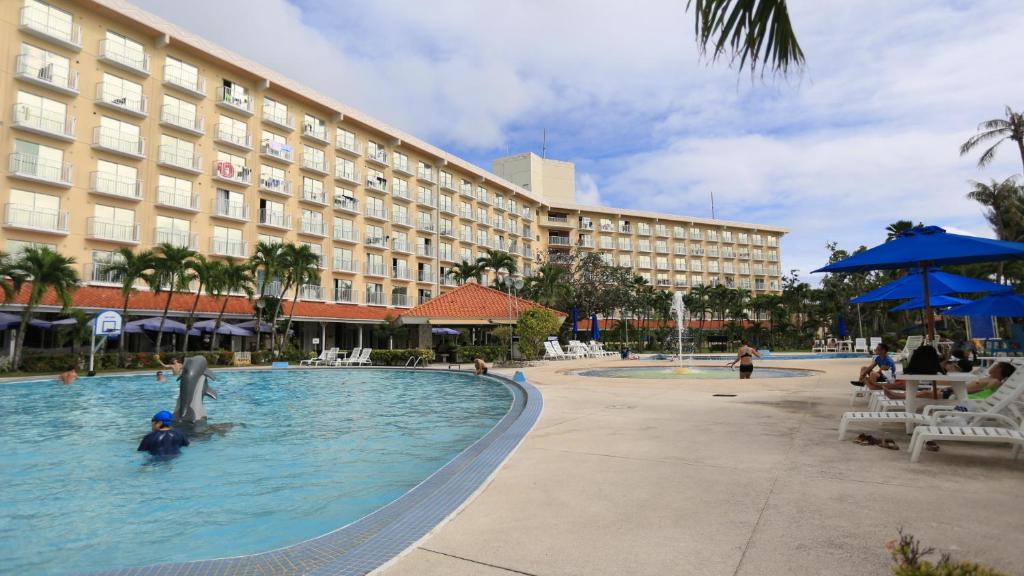 un hotel con piscina frente a un edificio en Grandvrio Resort Saipan, en Garapan