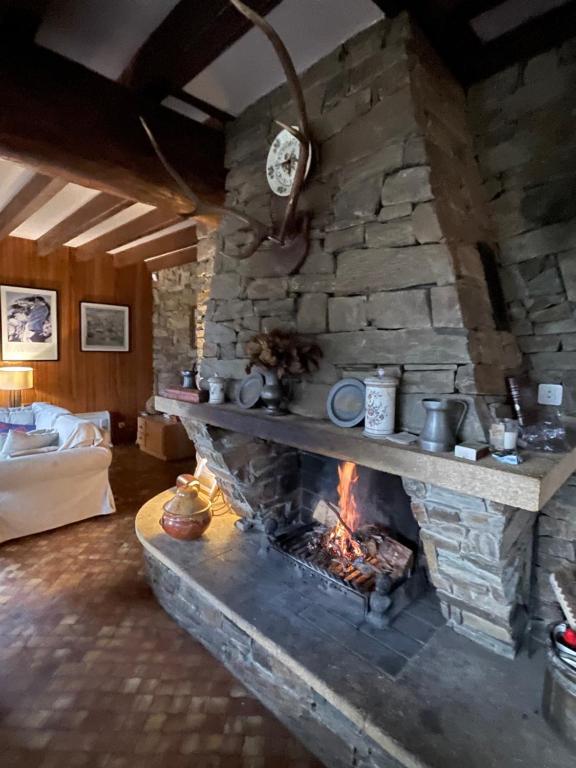 a fireplace in a living room with a stone wall at Family Cottage with a View in Mont-Louis