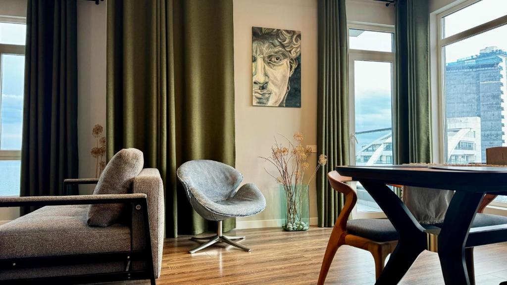 a living room with a table and two chairs at Stylish apartments White Sails View in Batumi