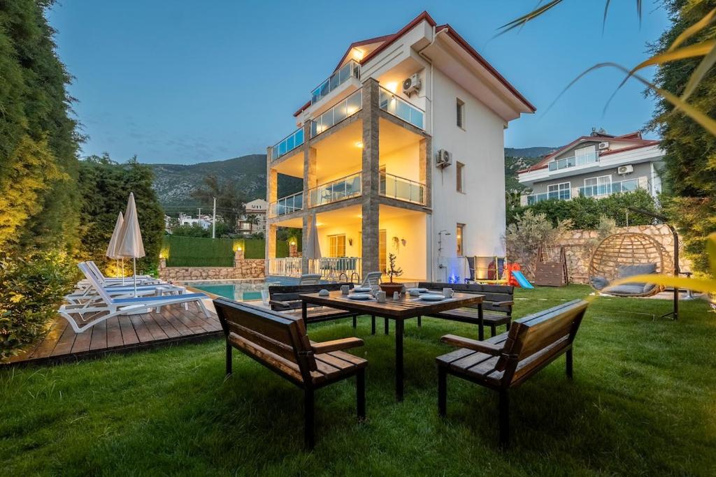 una casa con tavolo e sedie nel cortile di Ölüdeniz, Villa Solvento a Fethiye