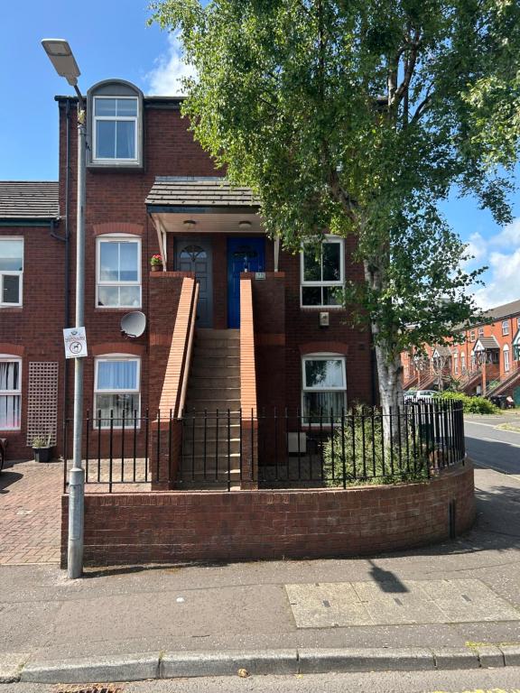 una casa de ladrillo con una valla delante en Tourist board certified Super city centre apartment with free parking, en Belfast