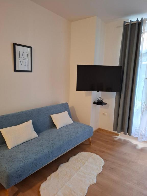 un soggiorno con un divano blu e una TV a schermo piatto di City Studio Ana a Fiume (Rijeka)